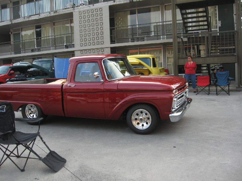 1966 Ford F-100 pickup truck, side view, parked in front of a motel