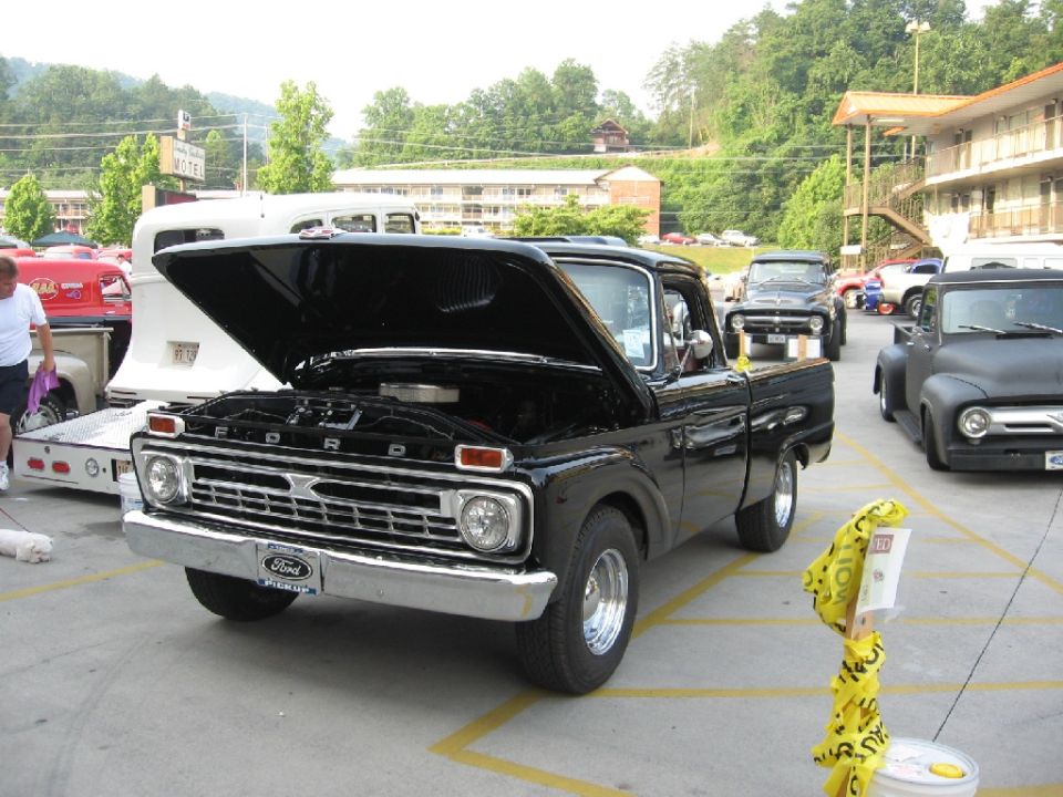 Black 1966 Ford F-100 pickup truck, hood open, parked outdoors