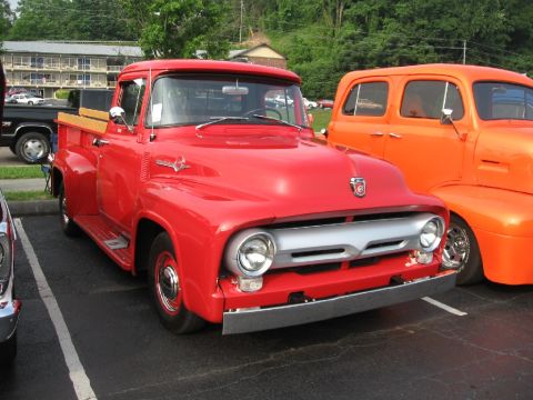 1966 Ford F-100 - A red 1955 Ford F-100 pickup truck is parked in a lot next to another vehicle.