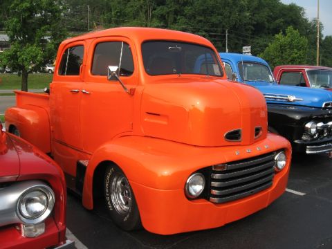 1966 Ford F-100 - This custom truck, likely a 1951 Ford F-series, is parked in a lot with other classic vehicles.