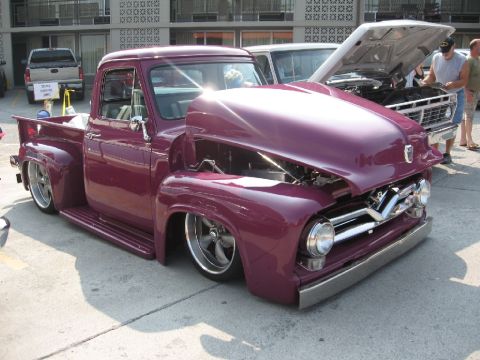 1966 Ford F-100 - Customized Ford pickup truck with its hood open, parked next to another truck.