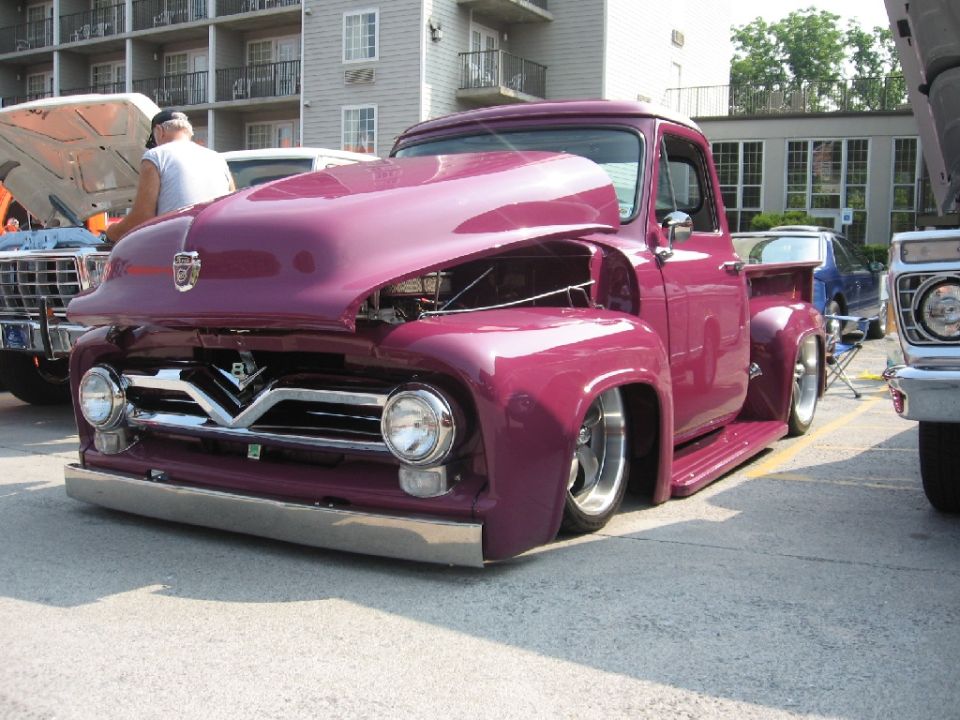 Purple pickup truck with hood open, lowered suspension, and custom grille