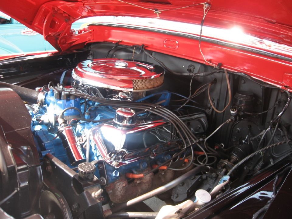 1966 Ford F-100 engine bay with chrome air cleaner and blue valve covers