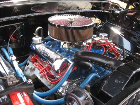 1966 Ford F-100 - Close-up view of a vehicle's engine bay, showing the engine block, air filter, and wiring.