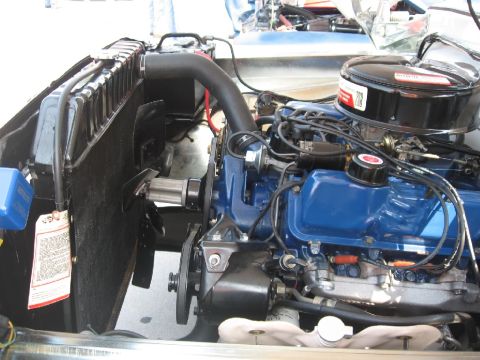1966 Ford F-100 - The engine bay of a vehicle, showing the radiator, blue engine block, and air filter assembly.