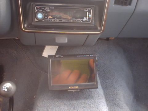 1990 Ford Bronco - Aftermarket stereo and screen installed in the dashboard of a vehicle.