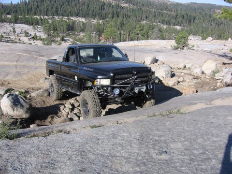 1989 Ford Bronco - This black pickup truck navigates a challenging rocky trail, its off-road capabilities.