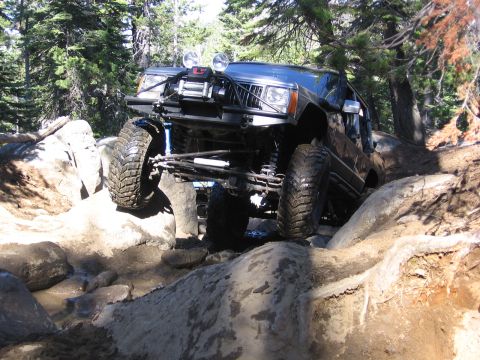 1989 Ford Bronco - This modified Jeep Cherokee navigates a challenging rocky terrain with a winch mounted on its front.