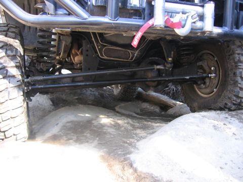 1989 Ford Bronco - Close-up view of the undercarriage and suspension of a modified off-road vehicle.