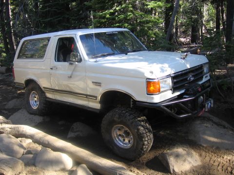 1989 Ford Bronco - This 1989 Ford Bronco is shown tackling a challenging rocky terrain, highlighting its off-road capabilities.