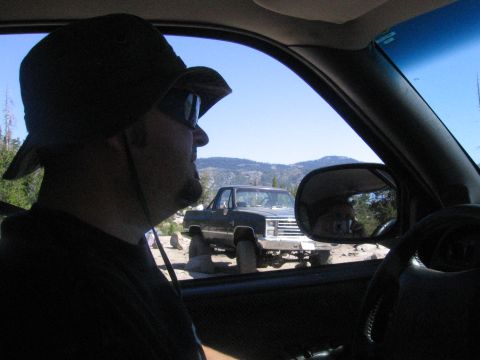 1989 Ford Bronco - A dark pickup truck, possibly a 1989 model, is seen off-road with another vehicle in the foreground.