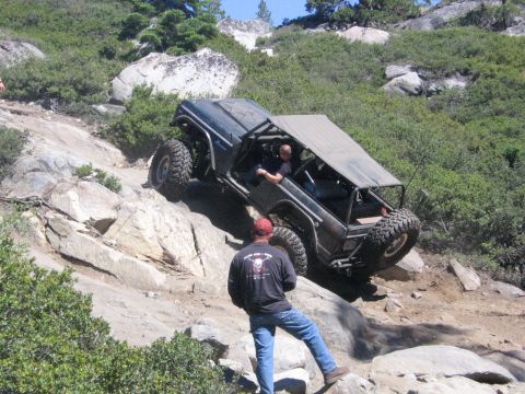 1989 Ford Bronco - An off-road vehicle navigates a challenging rocky terrain on a sunny day.