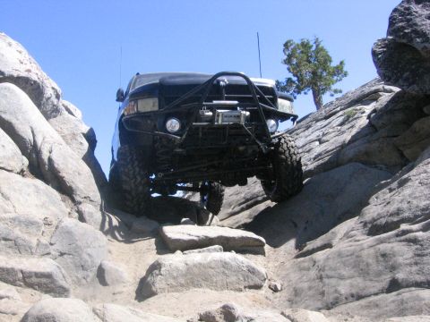 1989 Ford Bronco - This modified truck navigates a challenging rocky terrain, its off-road capabilities.