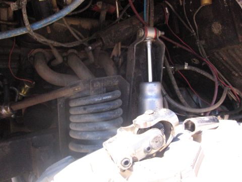 1989 Ford Bronco - The engine compartment reveals a suspension spring marked 'WILD HORSE' and a U-joint, suggesting off-road modifications.