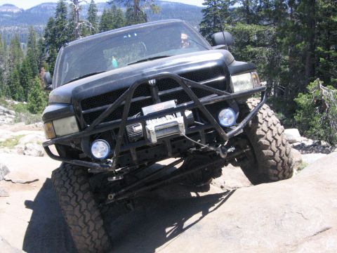 1989 Ford Bronco - A modified black Dodge Ram pickup truck navigates a challenging rocky trail.