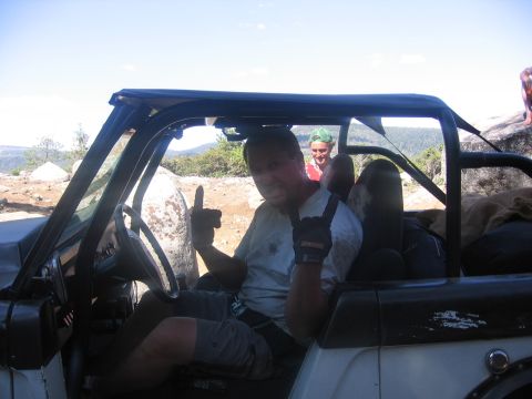 1989 Ford Bronco - Man in a 1989 Ford Bronco gives a 'rock-on' and thumbs-up gesture while off-roading.