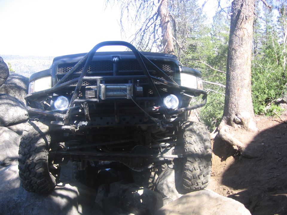 Black off-road truck with winch and custom bumper on rocks