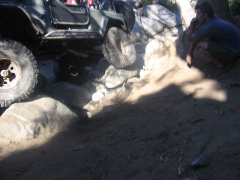 1989 Ford Bronco - A person watches an off-road vehicle navigate a rocky trail.