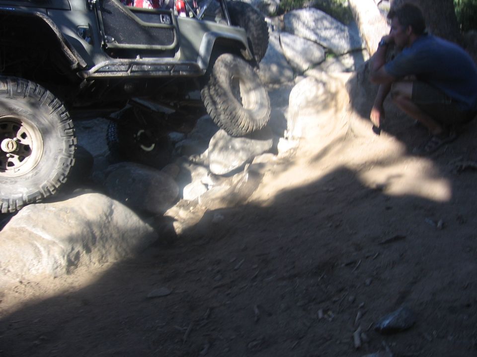 Off-road vehicle with large tires climbing over rocks