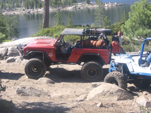 1989 Ford Bronco - Two Jeeps, a red CJ and a white Wrangler, are parked on a dirt road.