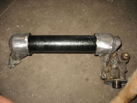 1995 Ford C-350 (Centurion Conversions) - An oil cooler assembly, a black painted tube and metal end caps, is shown on a concrete surface.