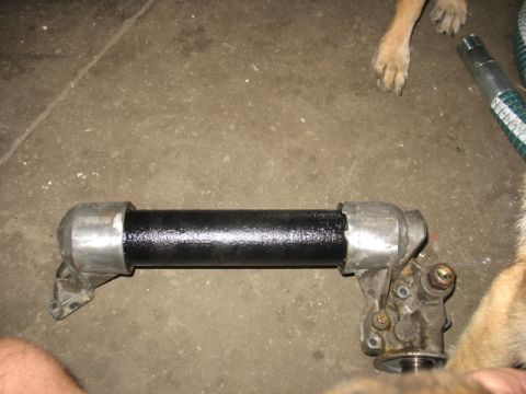 1995 Ford C-350 (Centurion Conversions) - Oil cooler assembly, likely for a vehicle, shown on a concrete surface with dog paws in the background.