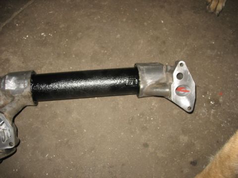 1995 Ford C-350 (Centurion Conversions) - A close-up view of an oil cooler pipe with a black-coated section and silver metal connectors.