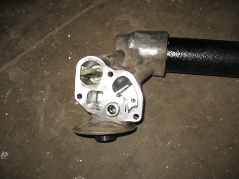 1995 Ford C-350 (Centurion Conversions) - Close-up of an automotive oil cooler housing, showing intricate internal mechanisms and a connected black pipe.