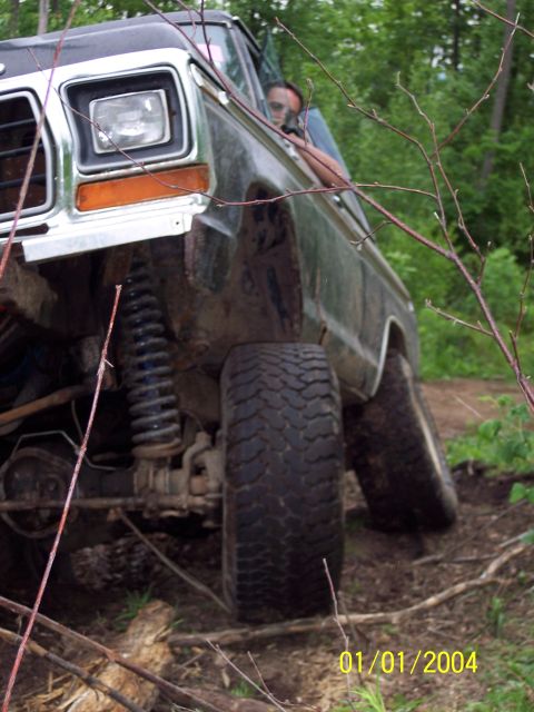 1979 Ford Bronco - A black 1978 Ford Bronco navigates rough terrain, showing its lifted suspension and off-road tires.