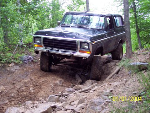 1979 Ford Bronco - Black Ford Bronco driving on a challenging rocky off-road trail.