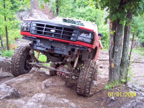 1979 Ford Bronco - This modified truck is navigating a rocky, off-road trail with a person in the driver's seat.