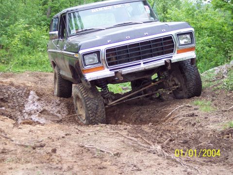 1979 Ford Bronco - Ford Bronco navigates a challenging muddy terrain during an off-road excursion.