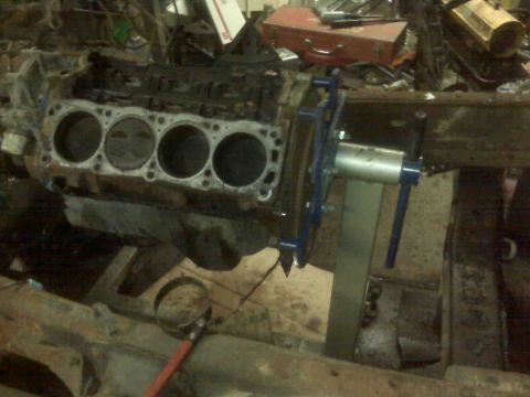 1995 Ford Bronco - An engine block is secured to a stand, ready for work in a cluttered garage environment.