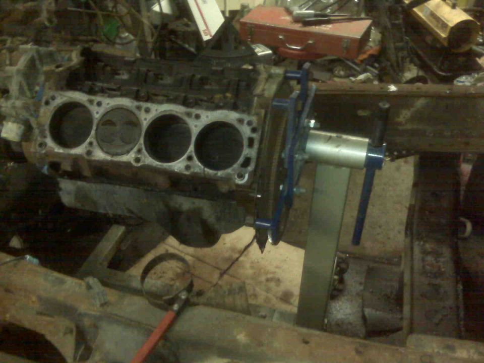 engine block with cylinders visible, mounted on a stand in a workshop