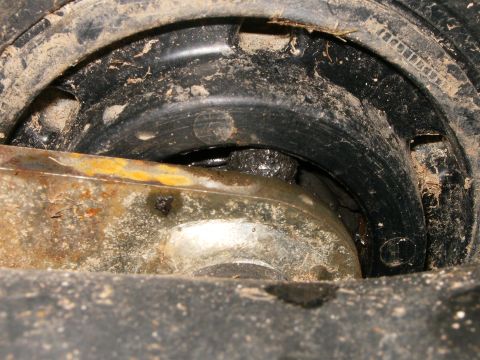 2000 Ford E350 - A close-up view of a dirty and greasy suspension component, likely from a vehicle's undercarriage.
