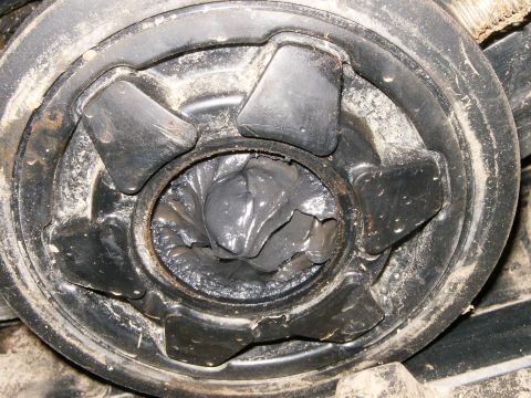 2000 Ford E350 - Close-up of a damaged driveshaft U-joint, showing old, dried grease and a torn boot.