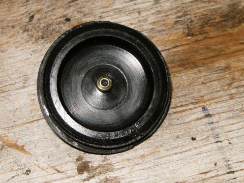 2000 Ford E350 - This black circular automotive part has a central brass fitting and is shown on a wooden surface.