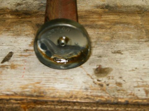 2000 Ford E350 - A close-up view of a metal cap, showing signs of wear and grease, on a wooden background.