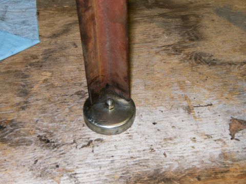 2000 Ford E350 - A close-up view of a metal bracket with a bolt, situated on a weathered wooden surface.