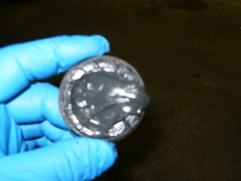 2000 Ford E350 - A gloved hand holds a round metal component covered in a dark grey substance.