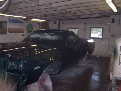 1975 Ford Ranchero - Vehicle in a garage, possibly being painted or restored, with its body on stands.