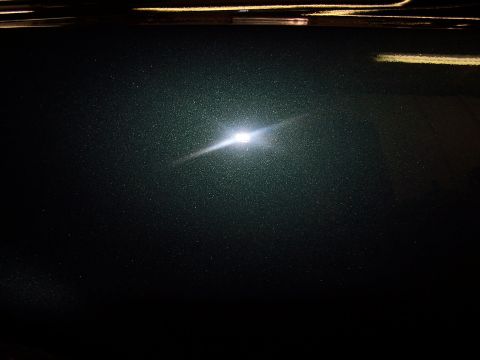 1975 Ford Ranchero - The photo shows a close-up of a vehicle's dark metallic paint with a bright light reflection. The Supermotors.net logo is visible in the co…
