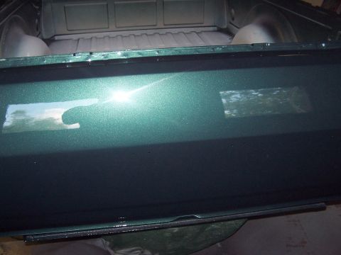 1975 Ford Ranchero - Close-up of a green metallic pickup truck bed, showing reflections on its surface.