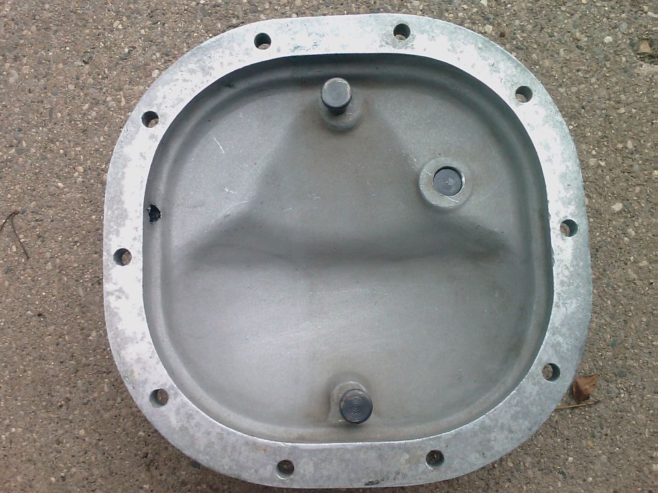 Bare stamped-steel differential cover lying on concrete