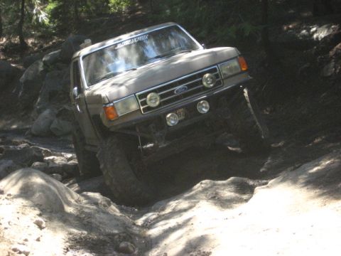 1989 Ford Bronco - This 1989 Ford Bronco is shown tackling a difficult off-road obstacle with large rocks and dirt.