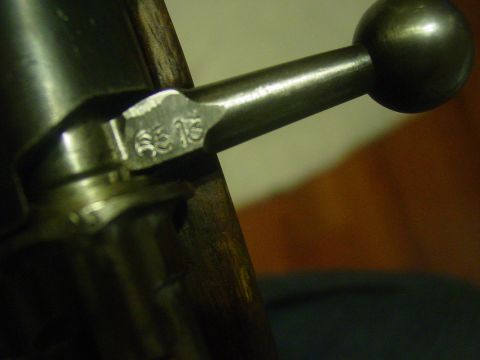 1979 Ford Bronco - Close-up of a firearm bolt handle showing a stamped serial number.