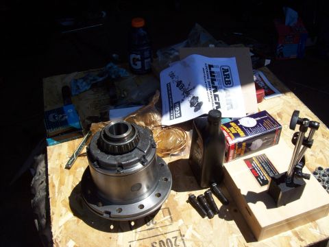 1995 Ford Bronco - Various automotive parts, including a differential locker and installation manual, are laid out on a wooden surface.