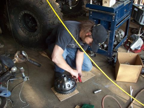 1995 Ford Bronco - Mechanic assembling a differential part in a workshop setting.