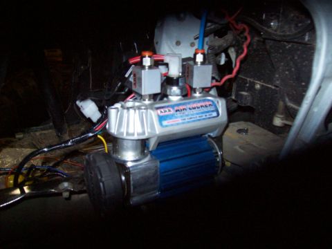 1995 Ford Bronco - An ARB air locker compressor is visible, a blue finned motor and silver housing with red and orange fittings.