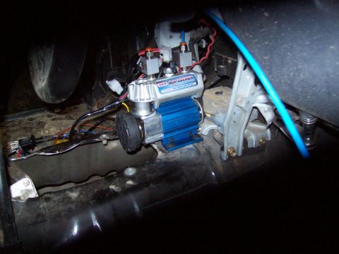 1995 Ford Bronco - Close-up of an ARB Air Locker compressor unit with blue fins and silver casing, installed inside a vehicle.